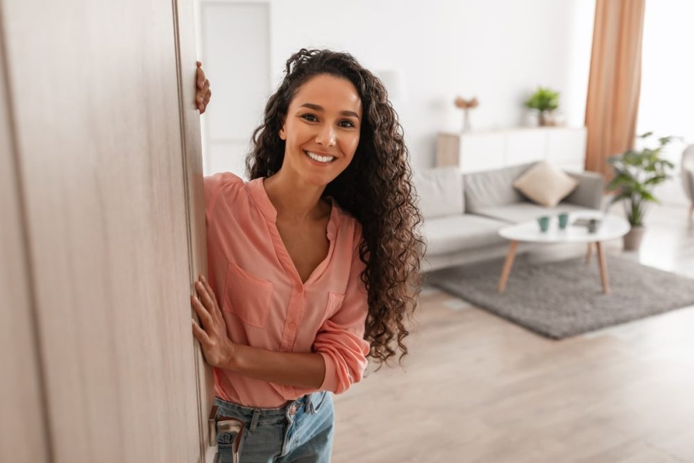 Smiling woman opening the door to her landlord.