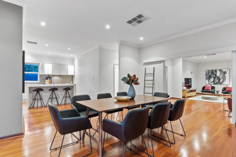 Large dining area with a rectangle table and black material chairs.