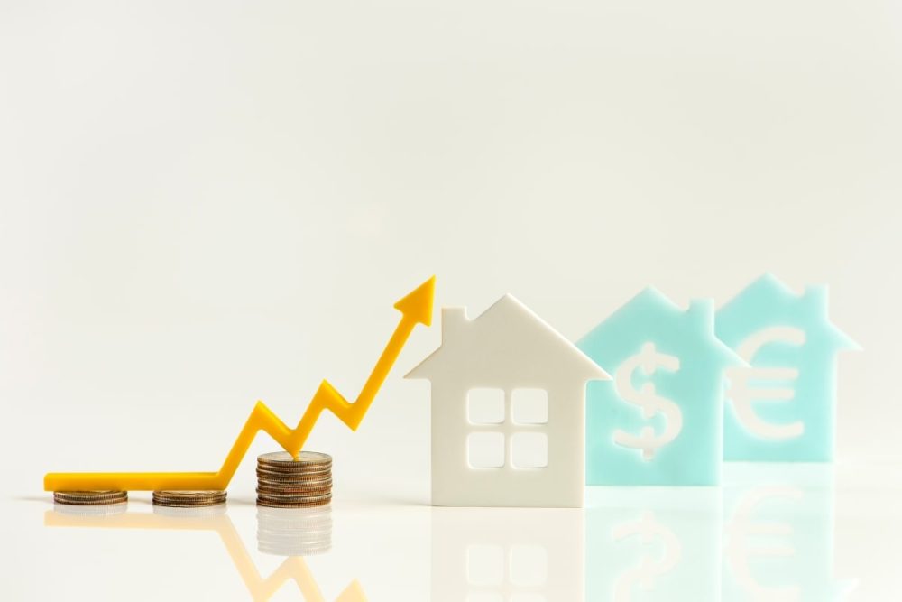 A graphical representation of housing market investment, featuring a growth arrow and homes with international currency signs, highlighting questions about market trends when buying a house.