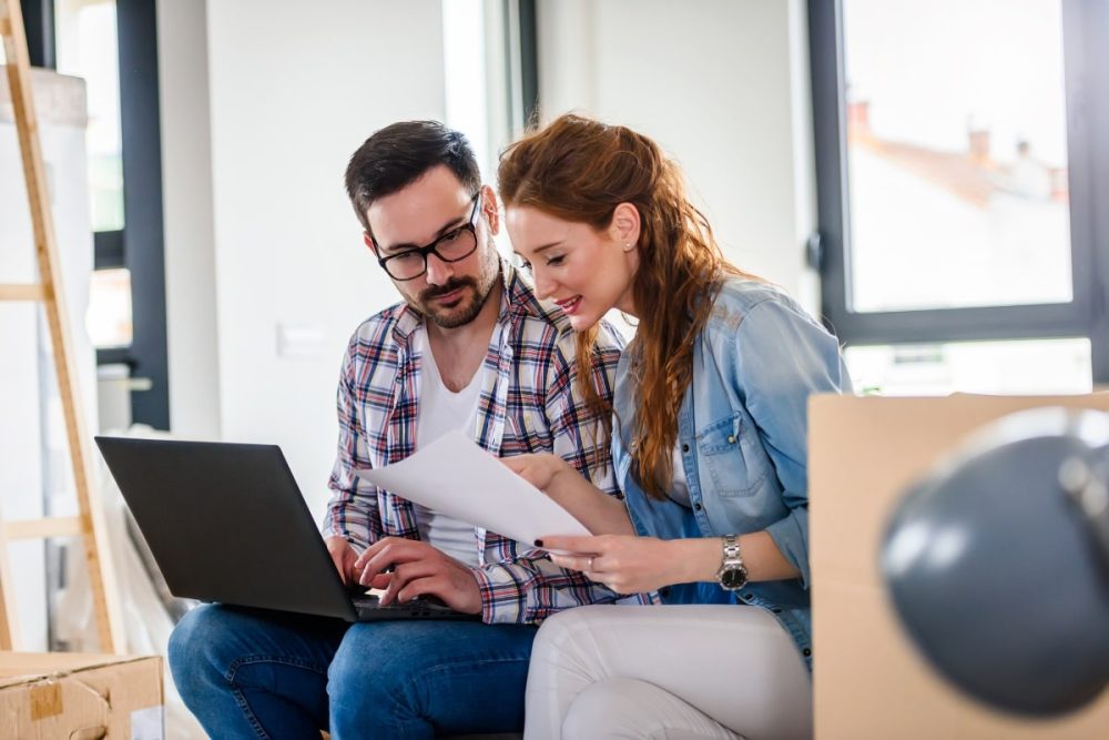 A man and woman sitting down, reviewing documents. This image highlights the importance of tenants maintaining detailed records of a rental property's condition.